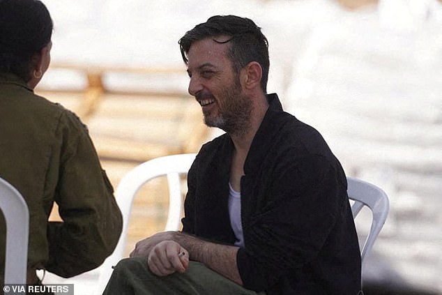 Released Israeli hostage, David Cunio, held in Gaza since the deadly October 7, 2023 attack by Hamas, sits with a representative of the Israeli army after being released, as part of a prisoner-hostage swap and a ceasefire deal between Israel and Hamas, in Reim, Israel October 13, 2025