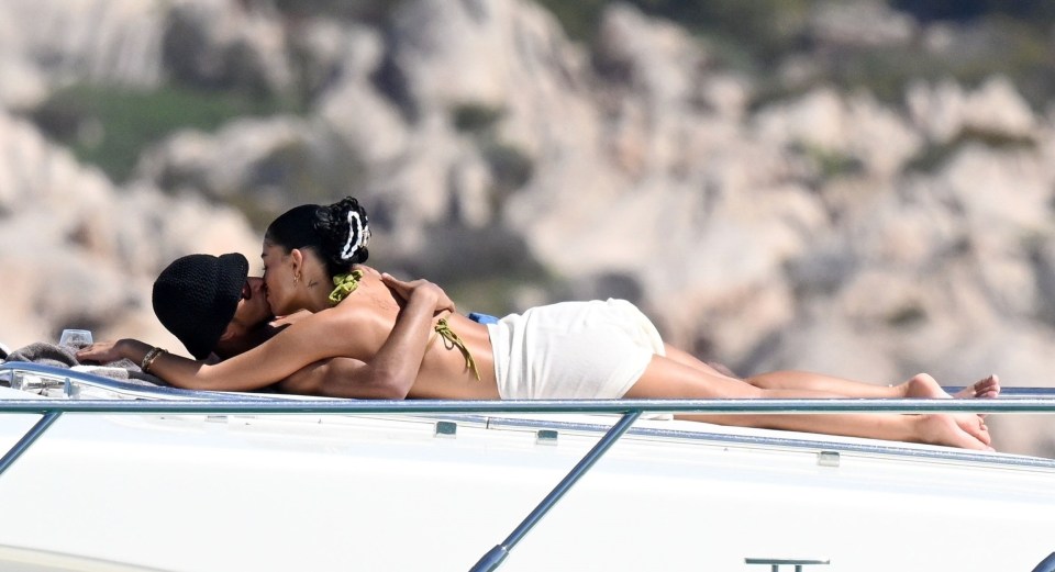 Jude Bellingham and Ashlyn Castro kissing on a luxury yacht in Sardinia.