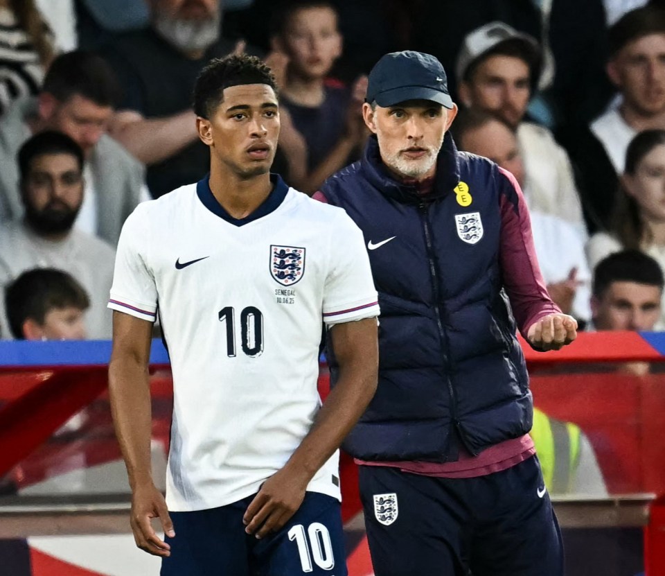 England's coach Thomas Tuchel speaks to midfielder Jude Bellingham before he enters the pitch.