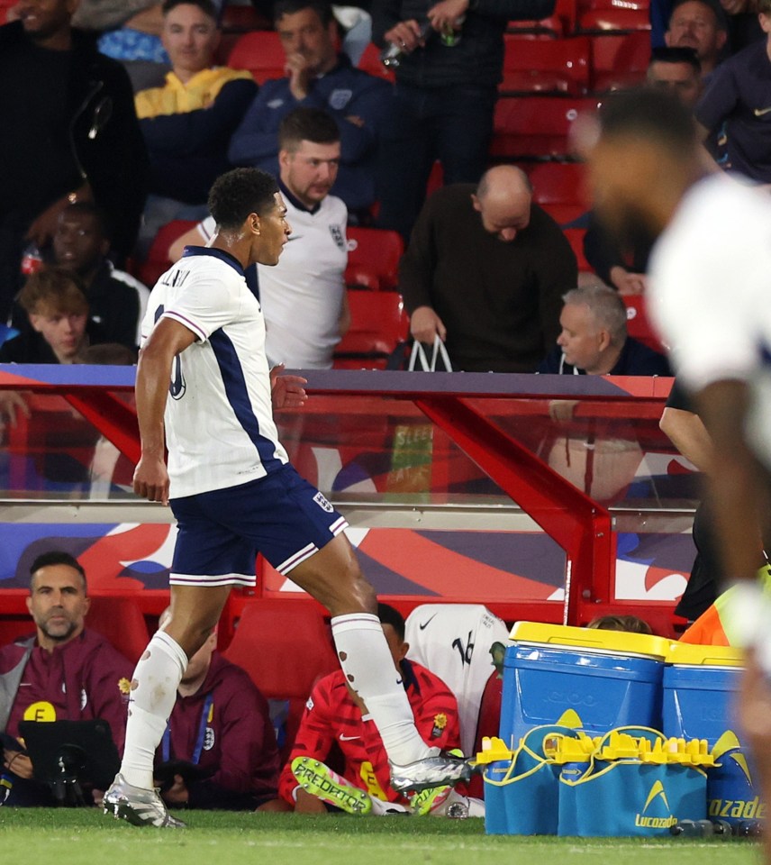 Jude Bellingham kicks Lucozade branded water bottles on the sideline.