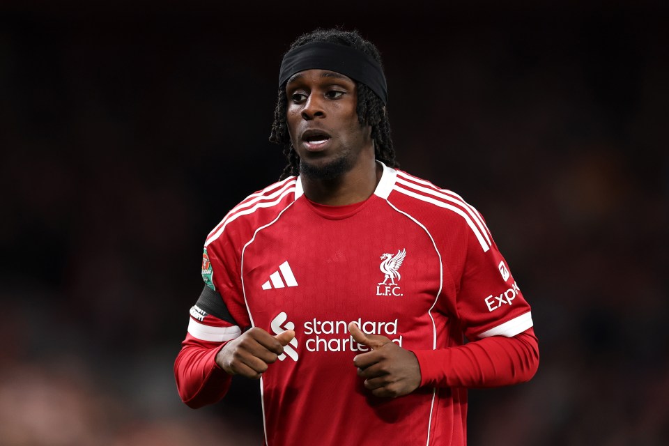 Jeremie Frimpong wearing a red Liverpool FC jersey with a black headband.