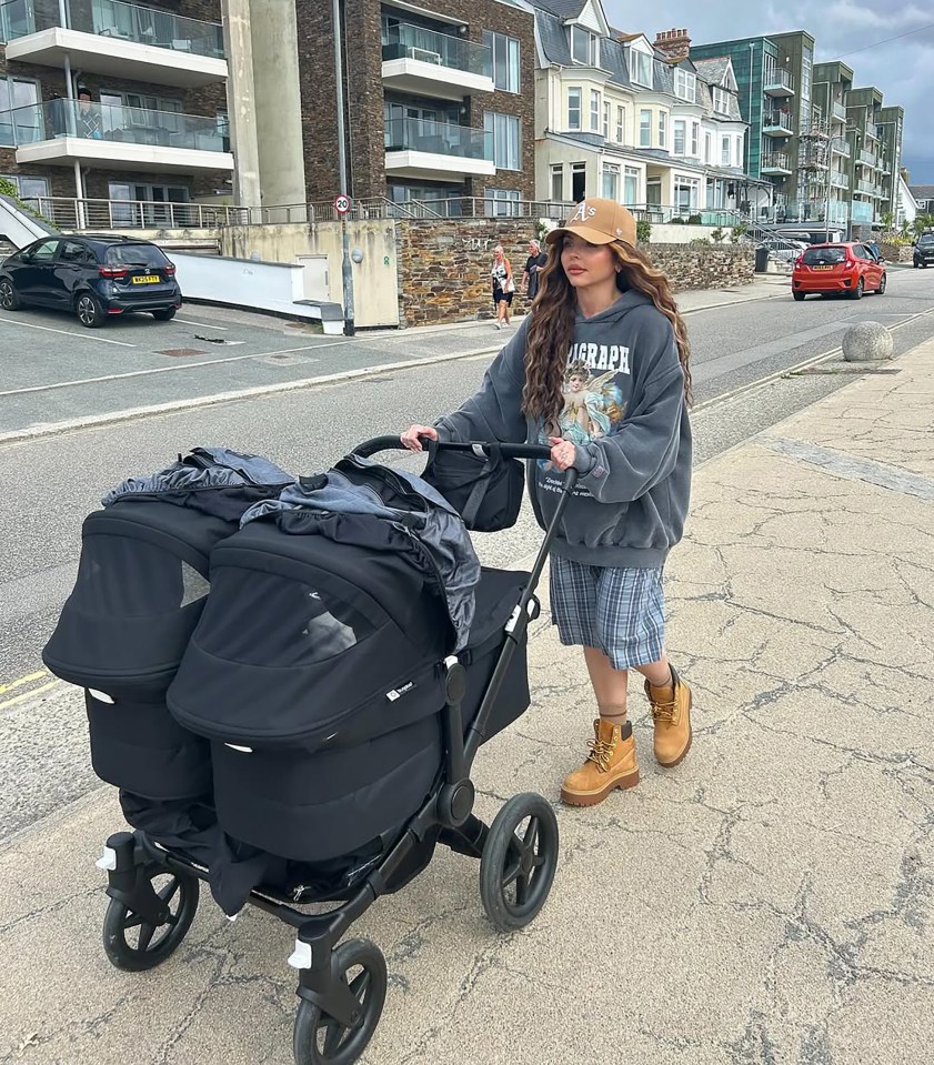 Woman pushing twin stroller.