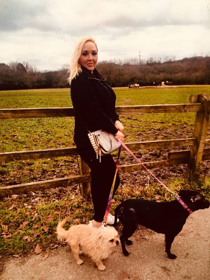Marie Buchan walking two dogs on a leash next to a muddy field.
