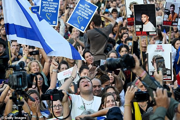 People react as they watch the hostage release live stream at Hostages Square in Tel Aviv