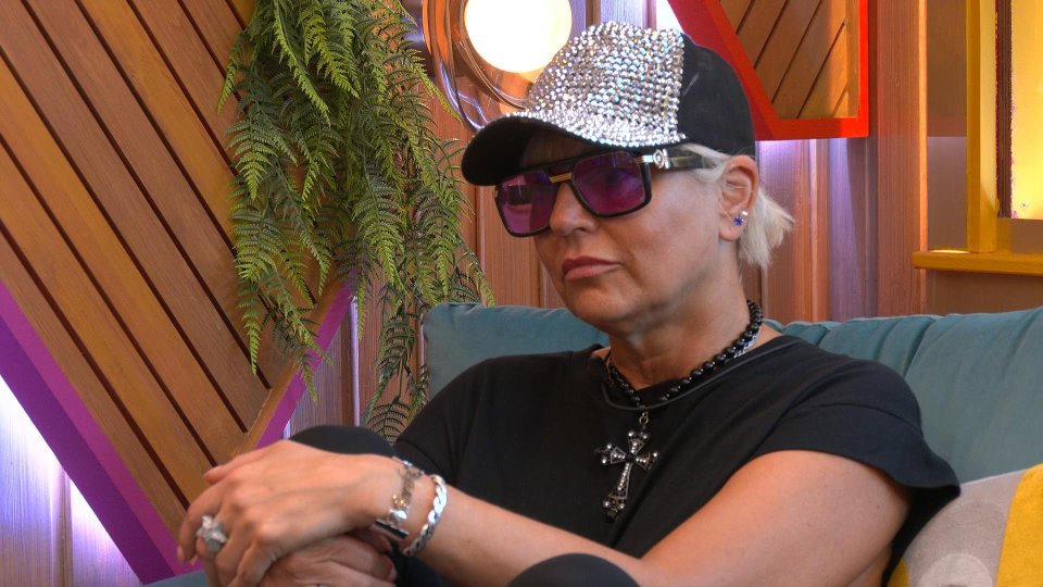 Caroline, a contestant on the TV show "Big Brother," sitting on a couch.