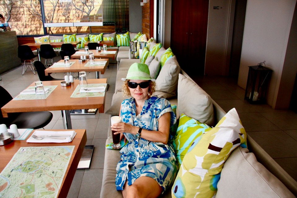 Sandra Parker sitting on a restaurant couch with a drink.