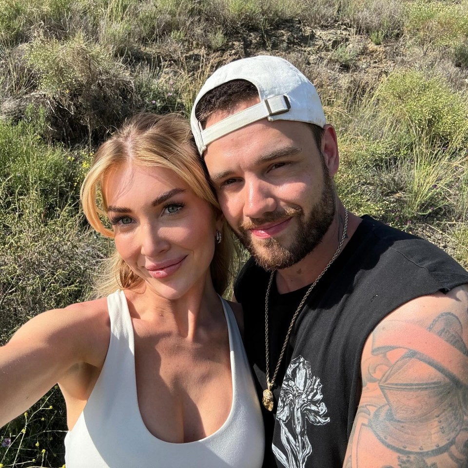 Kate Cassidy and Liam Payne posing for a selfie with a natural, grassy background.