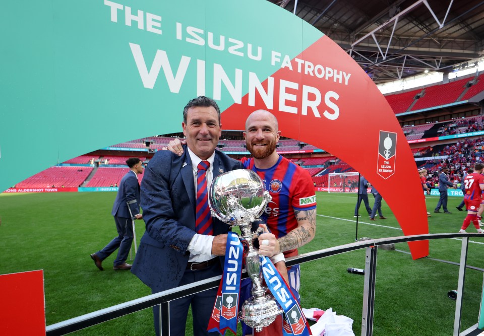 Tommy Widdrington and Theo Widdrington holding the Isuzu FA Trophy.