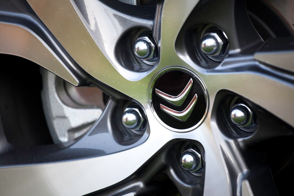 Close-up of a Citroën emblem on an aluminum wheel rim.