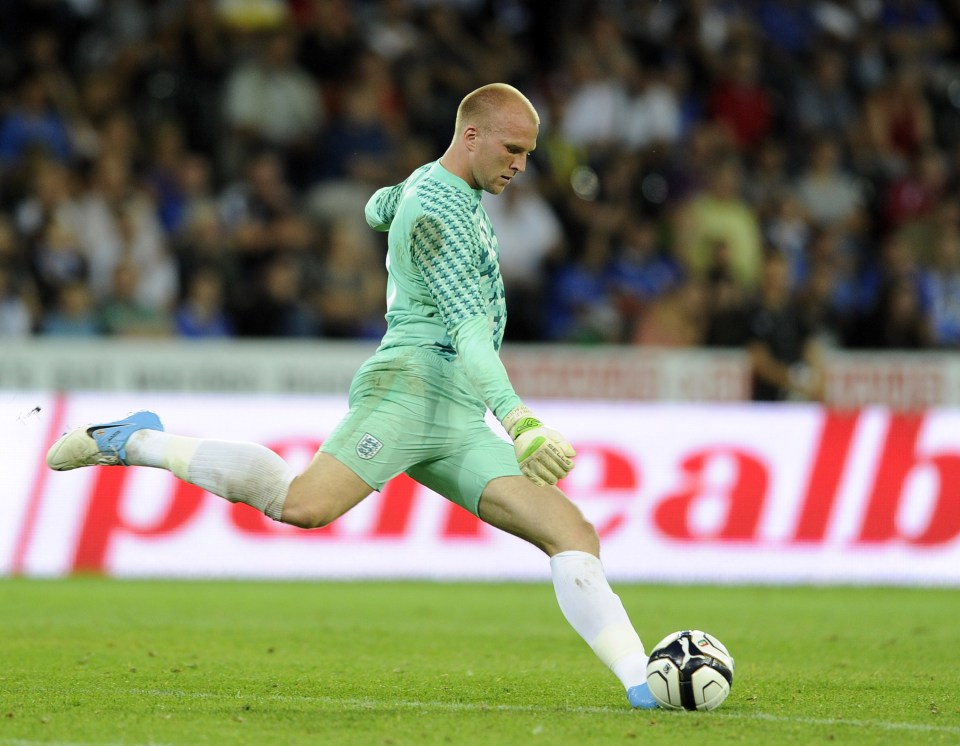 John Ruddy kicking a soccer ball in an international friendly match.