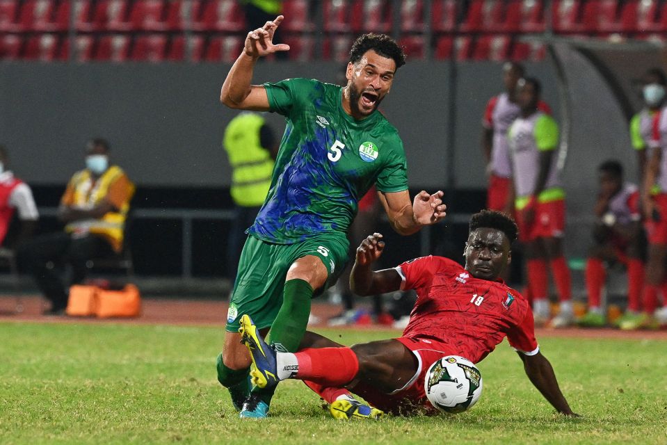 Sierra Leone defender Steven Caulker tackling Equatorial Guinea forward Luis Nlavo during a football match.