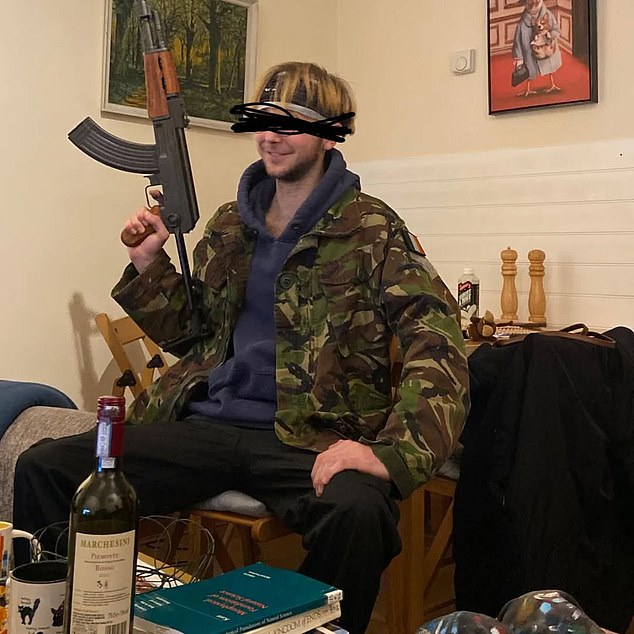 Mr Williams can be seen wearing a khaki military jacket and smirking while he waves a presumably fake gun in the air