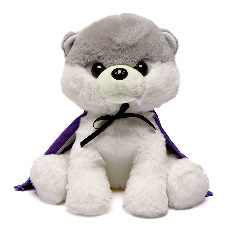 Gray and white plush wolf wearing a purple vampire cape with fangs.