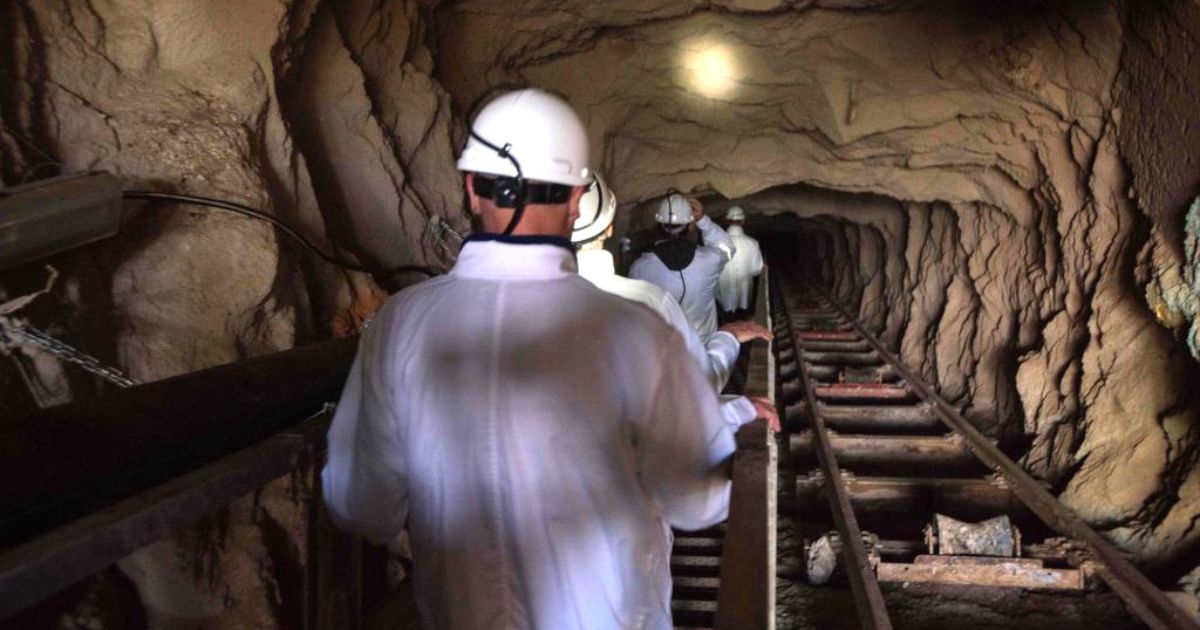 In a file photo from July 29, 2019, visitors walk down the inclined shaft at Steenkampskraal (SKK) rare-earth mine about 50 miles from the South African town of Vanrhynsdorp. SKK has been confirmed as one of the highest grade deposits of rare-earth minerals in the world. The rare-earth minerals are used in the manufacture of powerful magnets, which are used in electric vehicles, wind turbines, robotics, and many other applications.