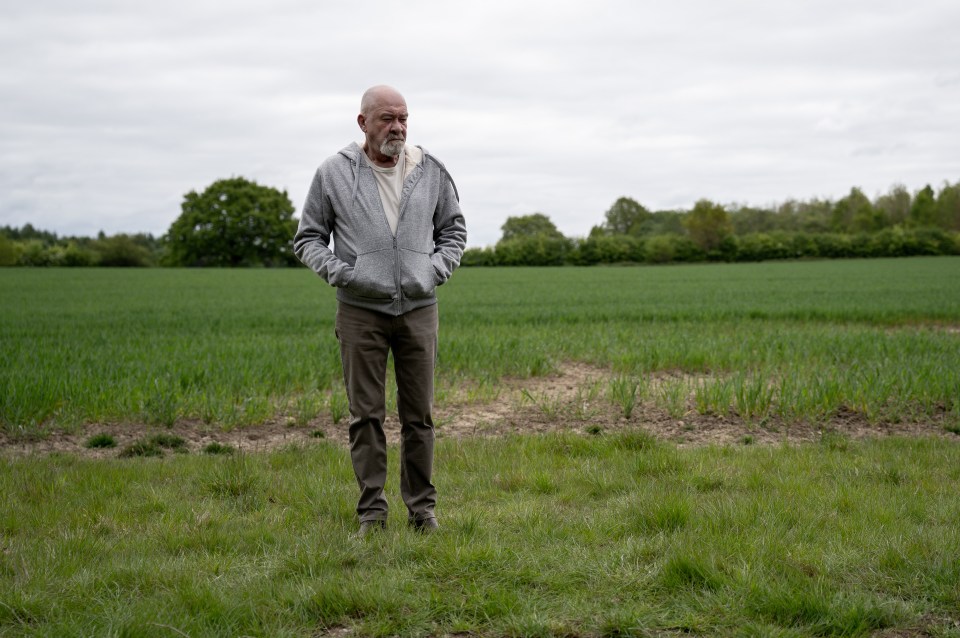 Bear Wolf (Joshua Richards) stands in a field.
