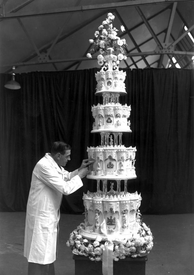 Mr. Schur, chief confectioner at McVitie and Price, putting the final touches to the four-tiered, nine-feet-high wedding cake of Princess Elizabeth and The Prince Philip, Duke of Edinburgh.