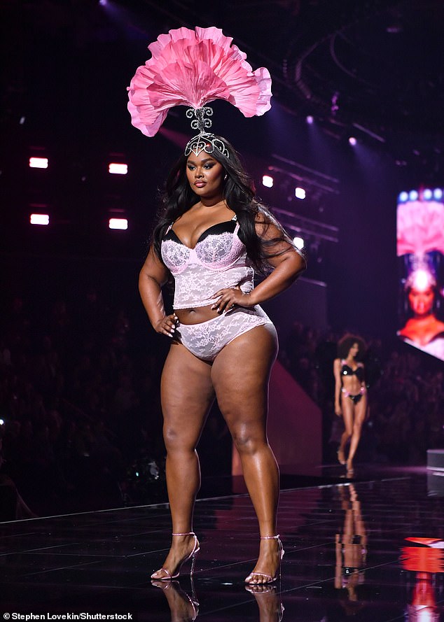 Precious Lee flaunted her curves in a black bra that peeked out over her pale pink lace bustier, which she wore with matching panties. She covered her long, lustrous raven tresses with a dramatic headdress decorated with a pink fan