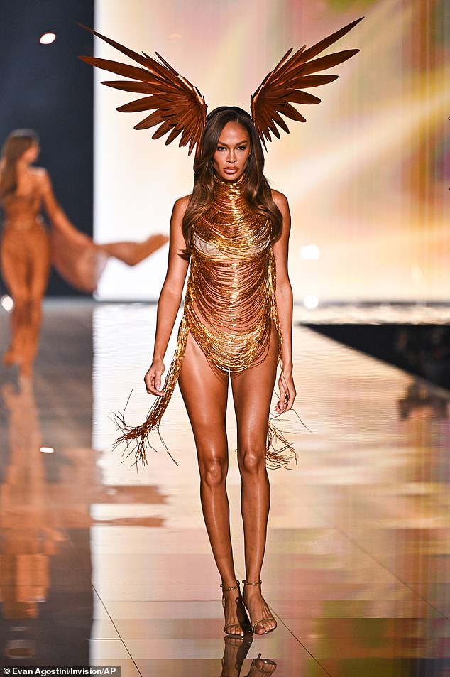 Joan Smalls looked elegant in a white bra and panties that were covered by a top of dangling gold strands. She wore small feathered wings attached to her head reminiscent of the Greek god Hermes