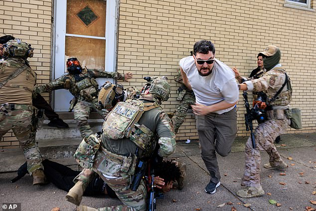 Government officials detain a protester and push back others in Chicago, Tuesday, October 14, 2025