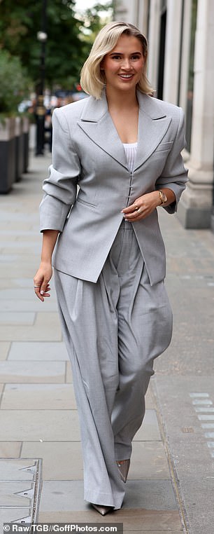 She was seen signing autographs as she arrived at the venue wearing a chic fitted grey blazer with shoulder pads