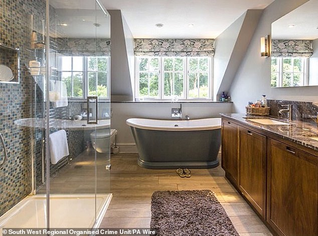 The bathroom features a walk-in shower, standalone bath and wooden flooring