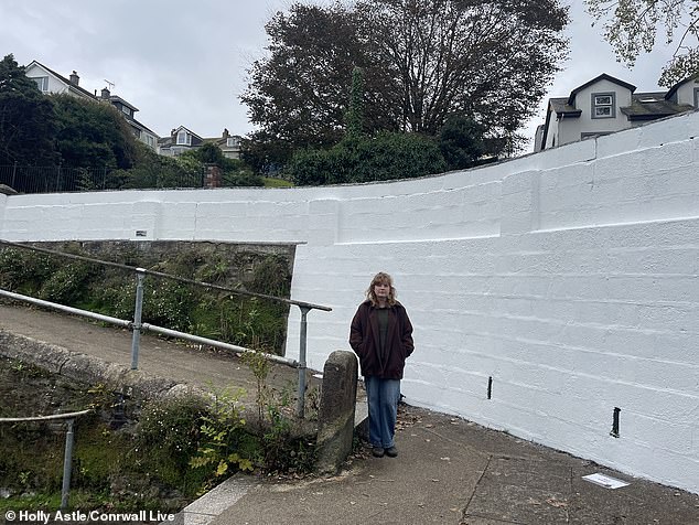 Ms Astle is pictured in front of the newly-painted wall in Falmouth where her mural used to be
