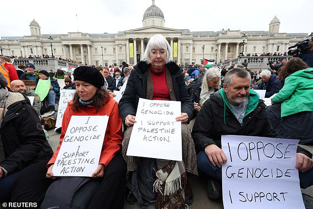 Protesters hold signs declaring their support for Palestine Action during a protest in Trafalgar Square, central London on October 4