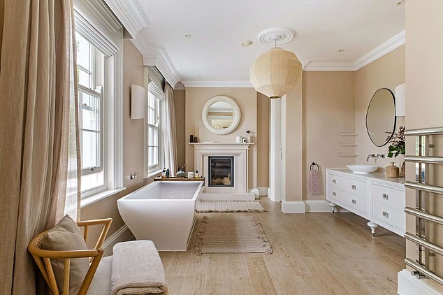 Pictured: the cosy bathroom and dressing room, with a bath and fireplace