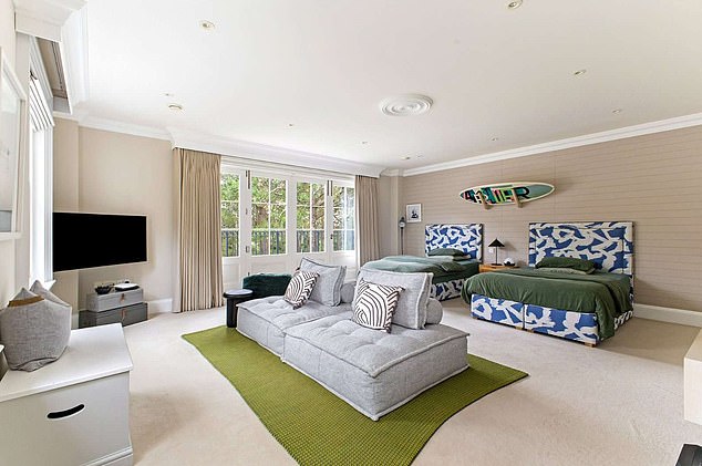 Pictured: another one of the large upstairs bedrooms complete with two king-sized beds and a  TV