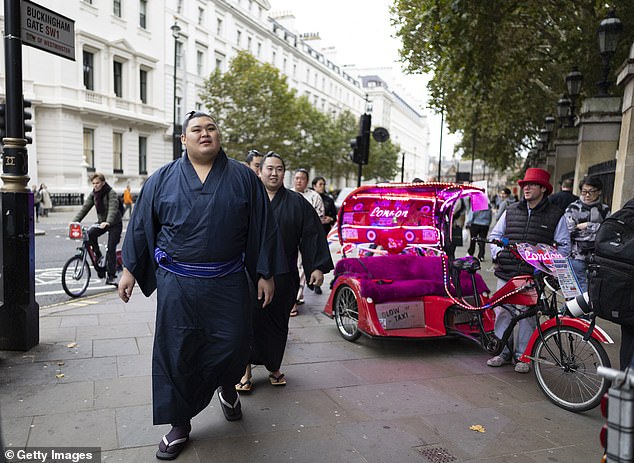 The wrestlers walked past rickshaw bike drivers near Buckingham Palace on October 14 as they indulged in a spot of London sightseeing