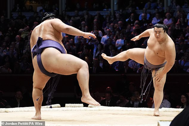 Wrestlers Tobizaru and Shonannoumi face down as they get ready to compete in the Makuuchi Division bout on day one of the event