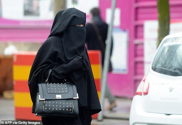 Portugal's proposed bill stipulates fines for those wearing face veils in public of up to 4,000 euros or £3,475. File photo: A woman wearing a niqab, a type of full veil as she walks down the street