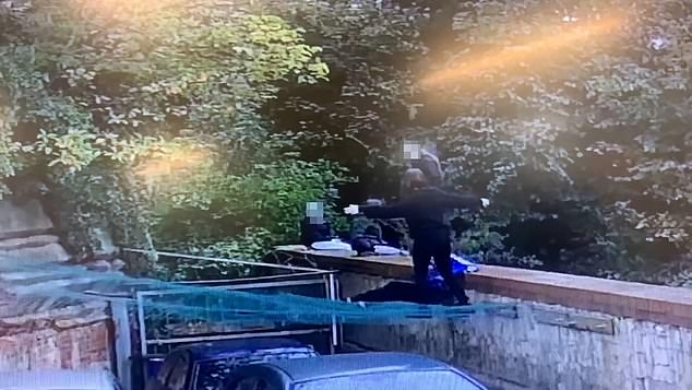 A teen stands on protective netting that Neil put up to prevent the cars being damaged
