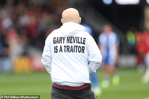 They wore white tops which took aim at the Salford chief and said: 'Gary Neville is a traitor'