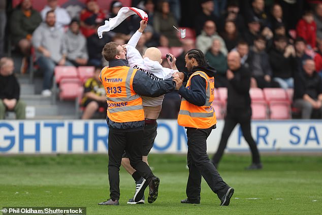 The fan in the centre of the pitch was apprehended by stewards, as was a fellow protester