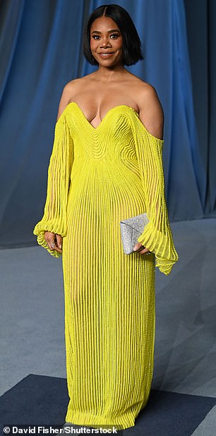 Regina Hall turned heads donning a strapless yellow dress and carried a shimmering silver clutch bag in her left hand