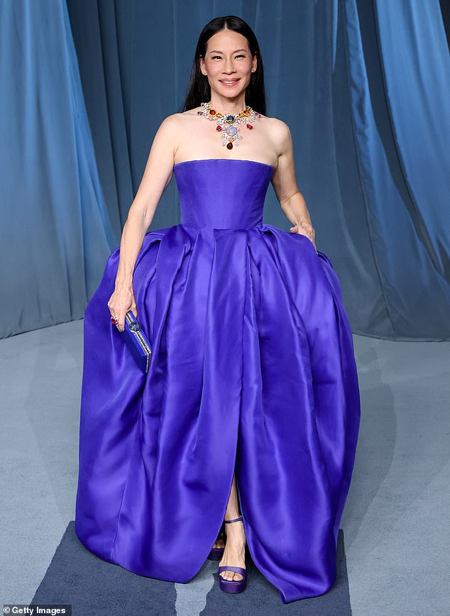 Lucy Liu was radiant while donning a vibrant purple dress with a corset bodice and full skirt that had a small slit on the front