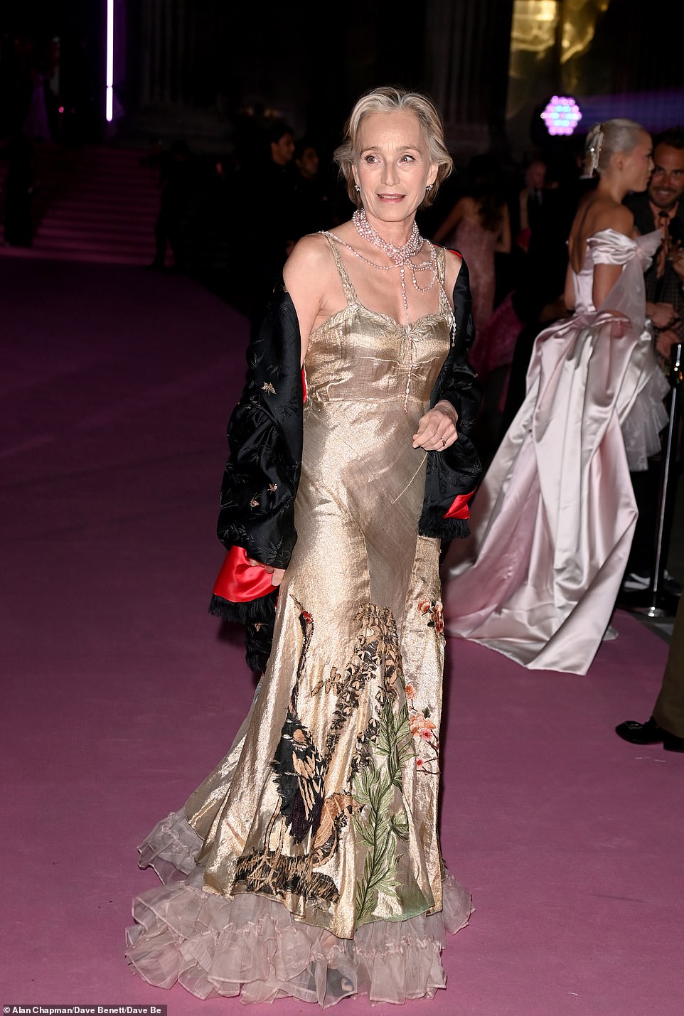Actress Dame Kristin Scott Thomas also opted for a metallic look, wearing a sleeveless gold gown adorned with floral embroidery and chiffon ruffles