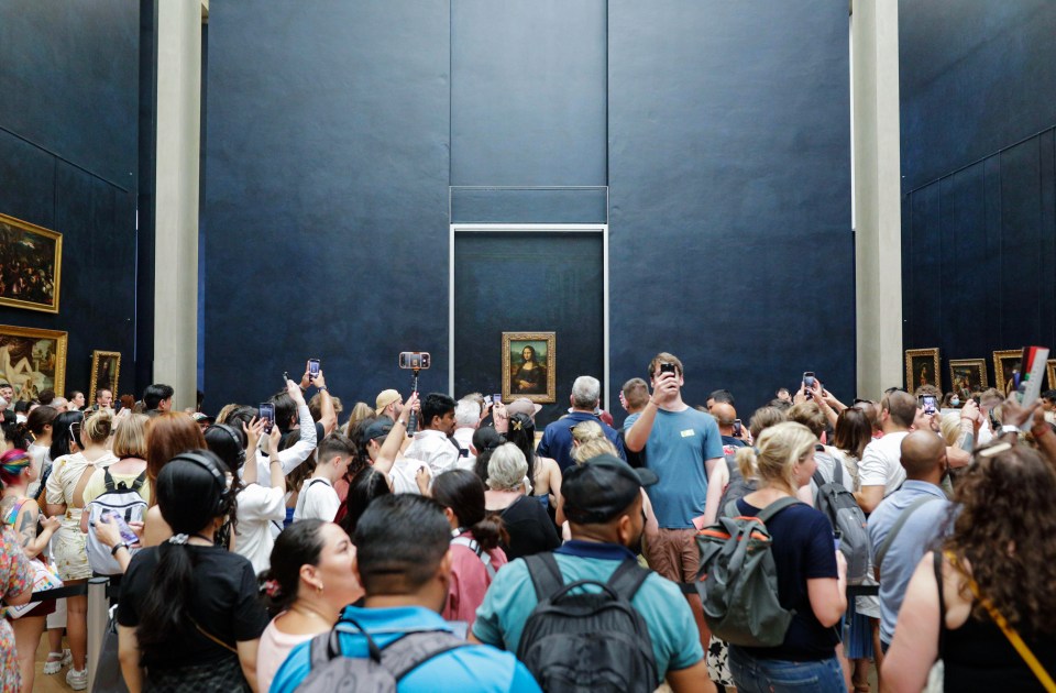 Paris, France - June 9, 2023: Tourists crowd to take photos of the famous Mona Lisa painting of Leonardo da Vinci inside the Louvre museum.