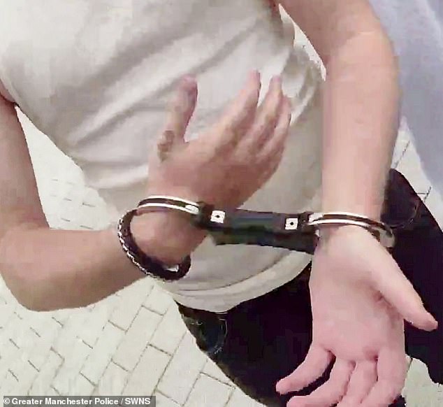 The busker appears to be packing up his equipment as the officer repeatedly asks him for his name but as he reuses he is then arrest and handcuffed