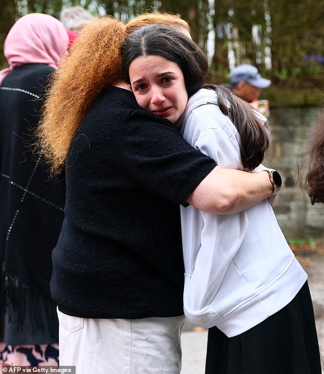 People in tears were seen comforting one another near the synagogue after the deadly attack