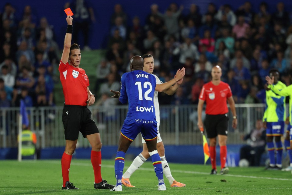 Spanish referee Jose Luis Munuera Montero shows a red card to Getafe's midfielder Allan-Romeo Nyom during a football match.
