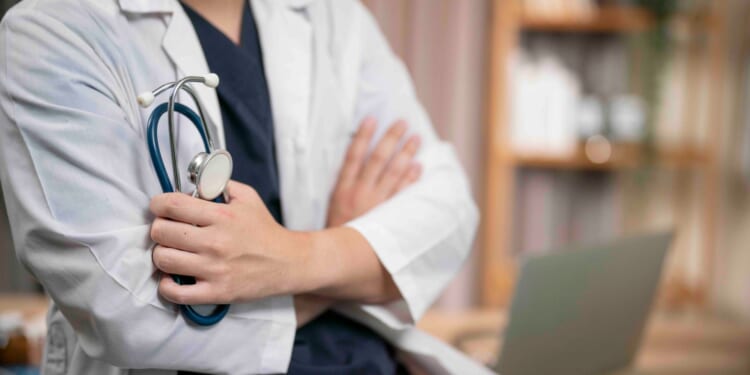 Top doctor who growled at colleague in 'sexually suggestive' way then 'jiggled' her breasts struck off