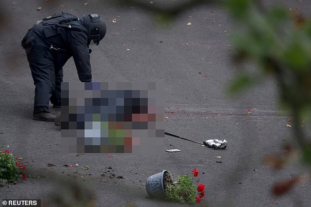 A bomb disposal technician works by the body of Al-Shamie after the attack