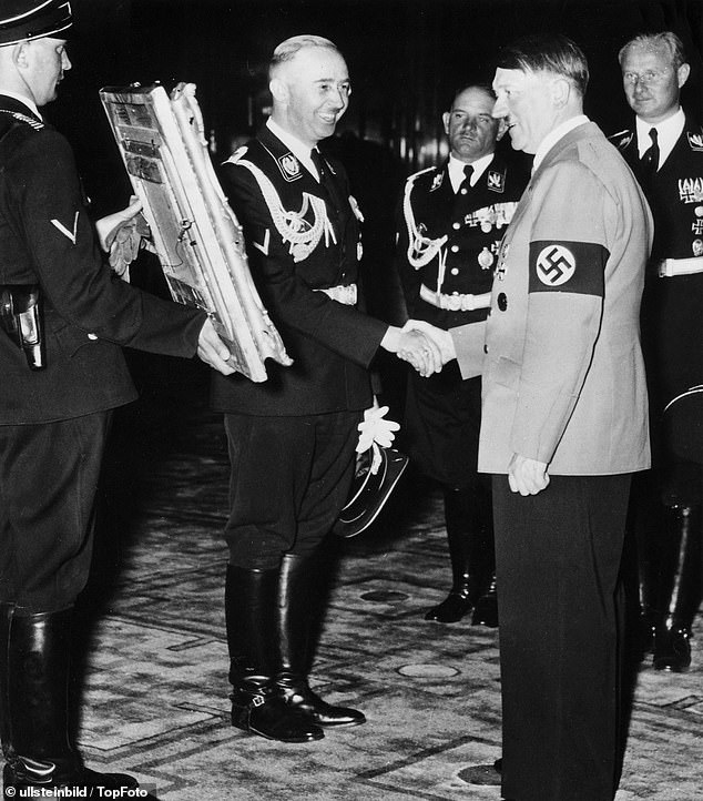 Himmler is pictured greeting Hitler with a painting as a 50th birthday present for him in 1939
