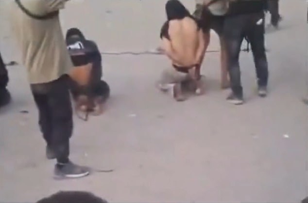 In the video, a crowd can be seen cheering as the men are slaughtered. There are chants of 'Allah Akbar,' or God is Great. The men are also called 'collaborators'