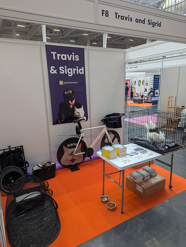 Influencer Travis Nelson said he was 'shocked' by how few people turned up to the event. Pictured: His cat Sigrid awaiting visitors to their stall at the show last month