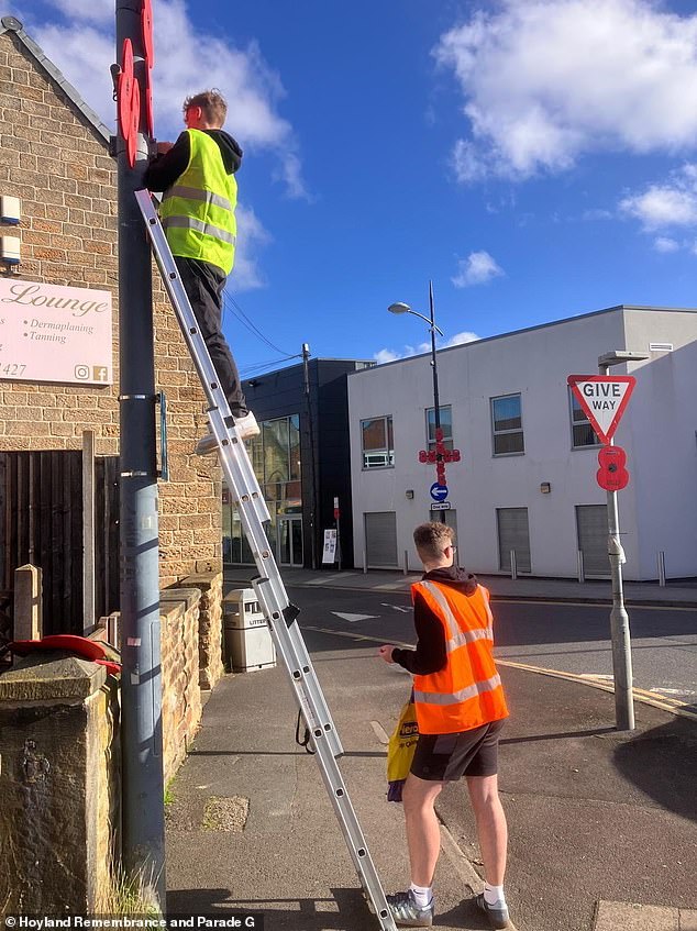 Volunteers putting poppies on a lamppost in the town of Hoyland, Barnsley