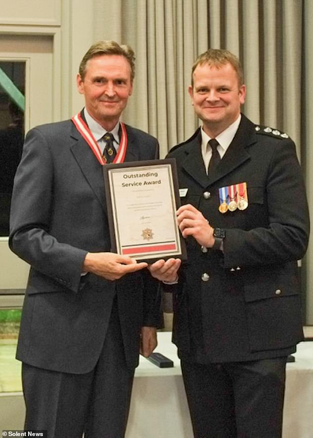 Pictured: Sacked firefighter John Linden (right) being awarded an Outstanding Service Award