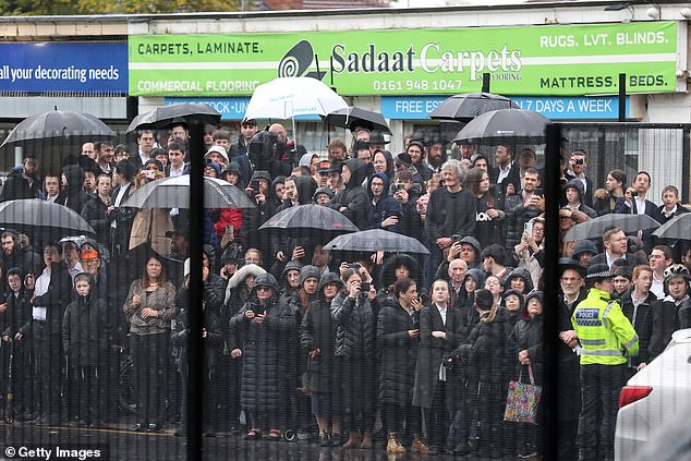 Members of the public wait to see King Charles III during his visit to the synagogue today